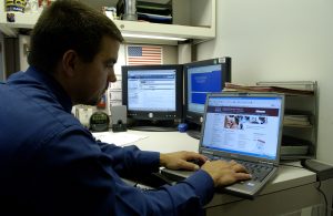Person using a laptop at a desk while researching content.