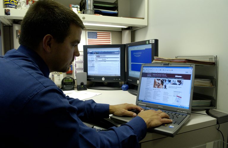 Person using a laptop at a desk while researching content.